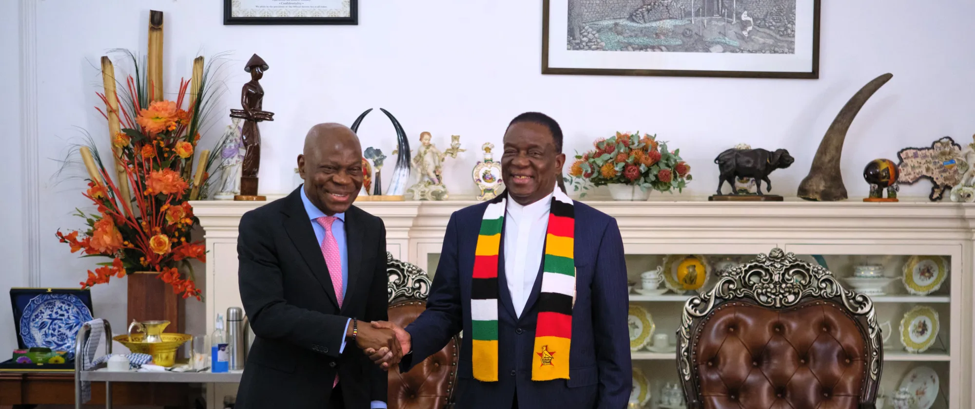 ILO Director-General, Gilbert F. Houngbo with Zimbabwean President Emmerson Mnangagwa standing in a room full of decorations