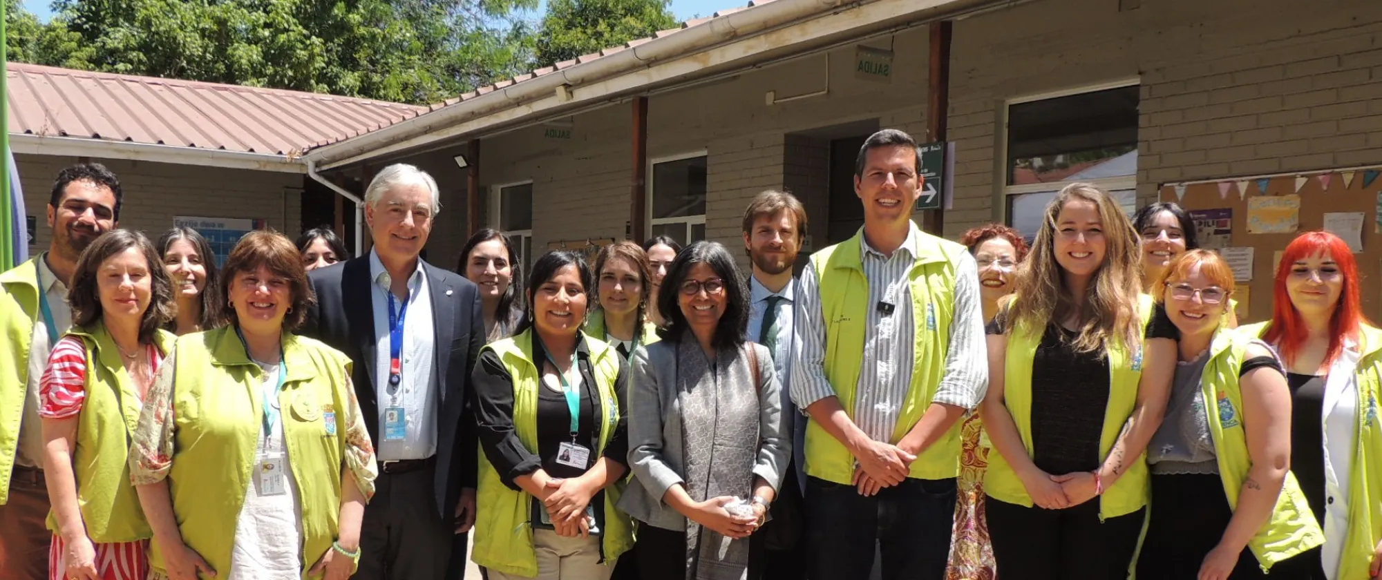 Grupo de personas reunidas posando en el frontis de un centro comunitario