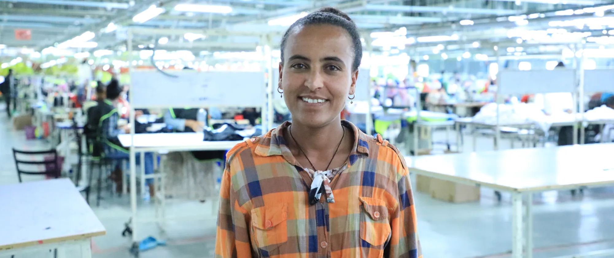 A worker in one of the factories standing before the production line