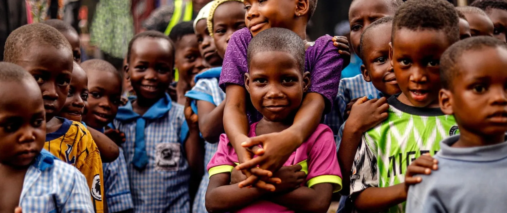 Children from Africa pose for a picture, two of them hug eachother