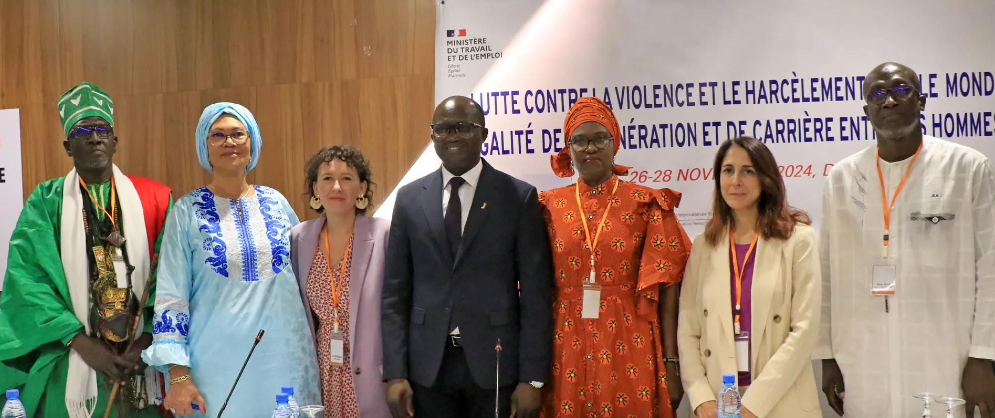 Photo de groupe lors d'une rencontre organisée à Dakar sur la prévention de la violence et du harcèlement dans le monde du travail. Les participants, représentant diverses parties prenantes, tiennent des brochures et des cartes rouges symbolisant leur engagement à promouvoir des lieux de travail sûrs, inclusifs et respectueux.