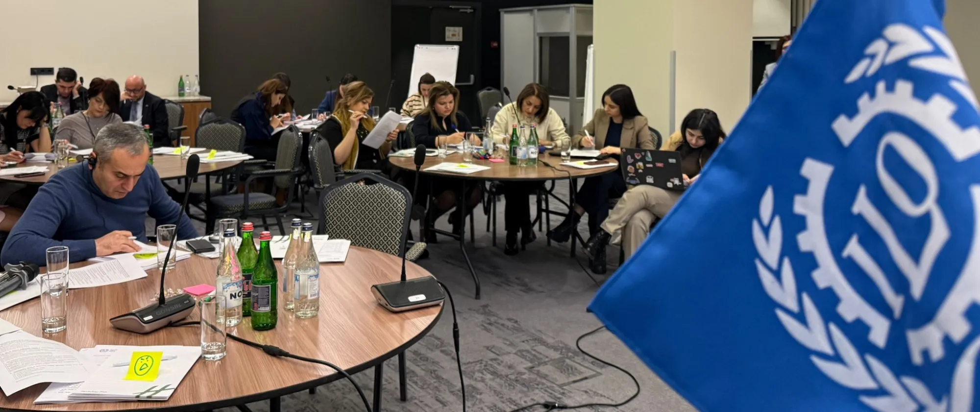 Participants of the ILO training on violence and harassment sit in groups at tables