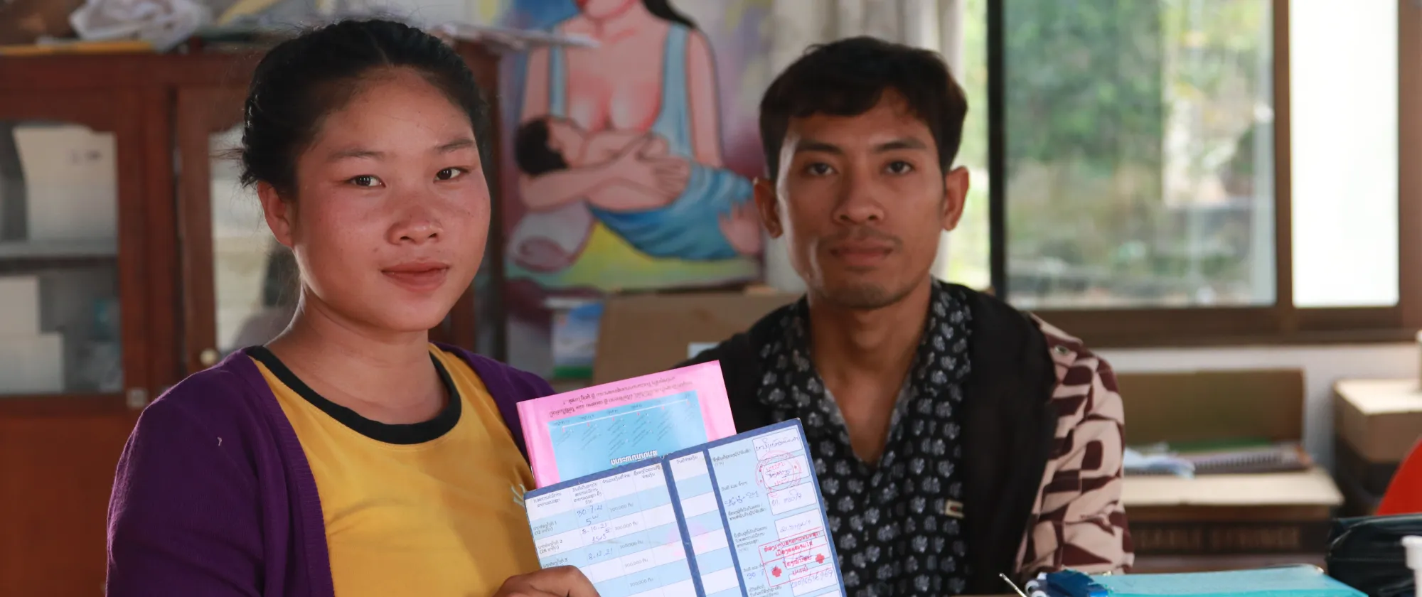 A pregnant woman holds documents. 