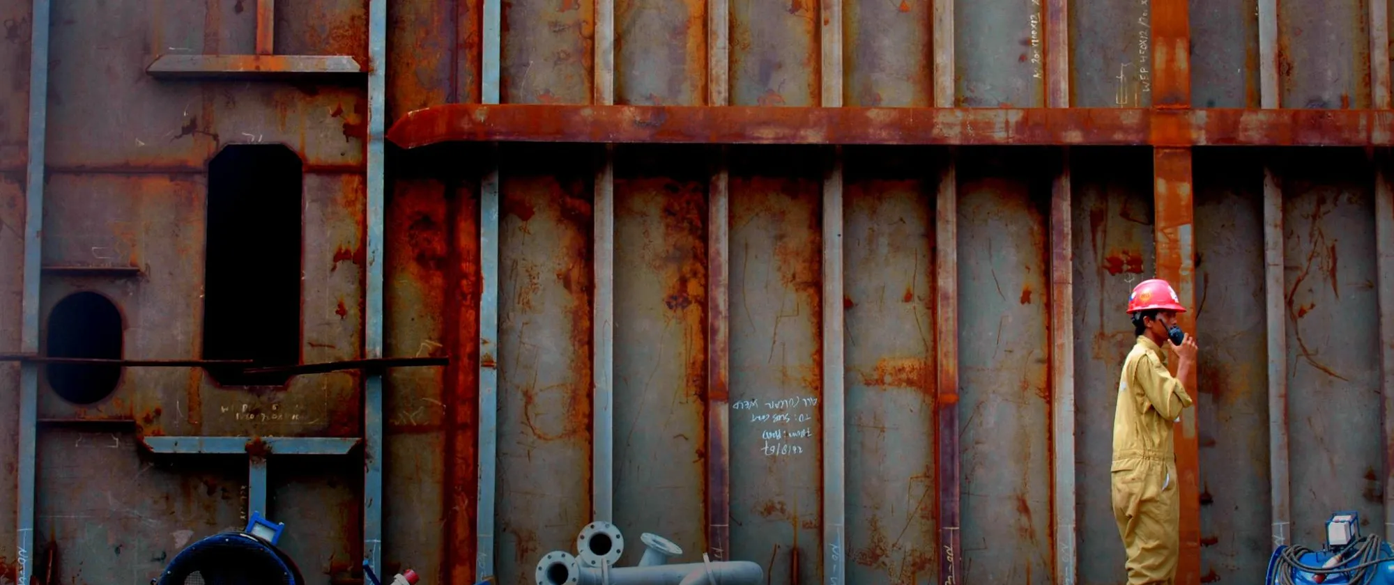 a male shipyard worker communicating through a handy talkie