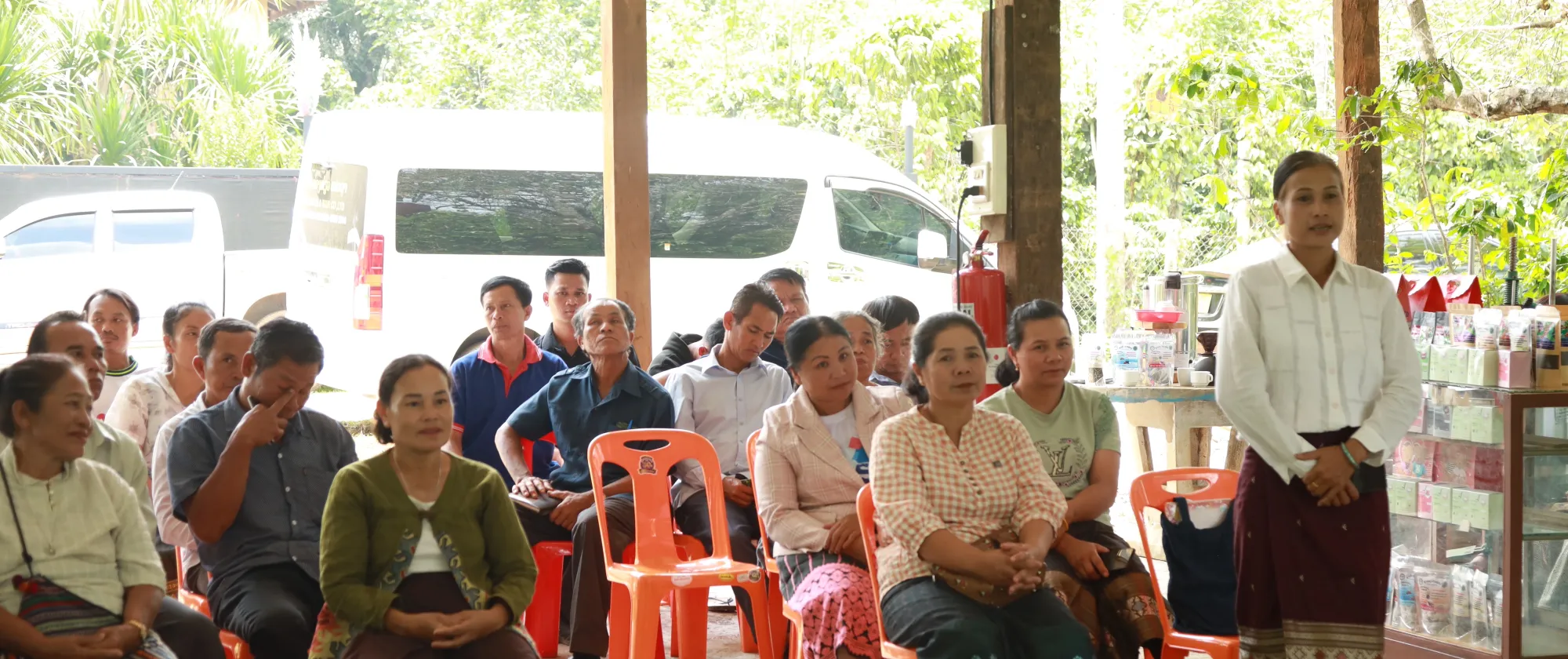 Women and men sitting on chairs. 
