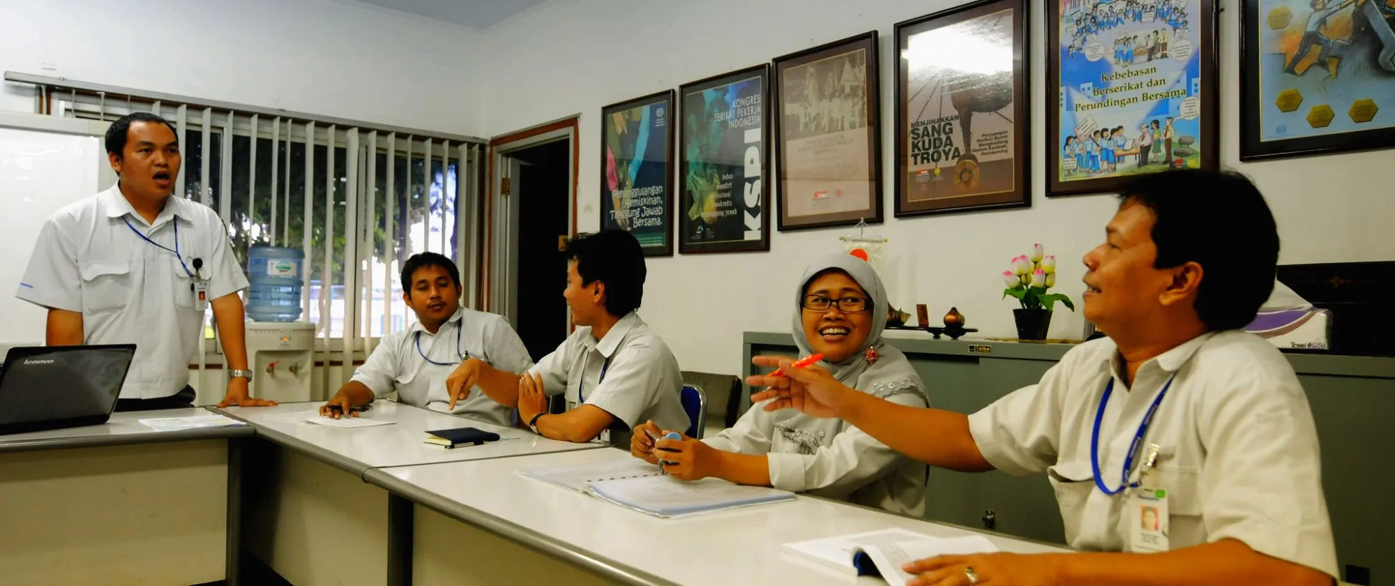 a woman and 4 men having discussions during their union meeting