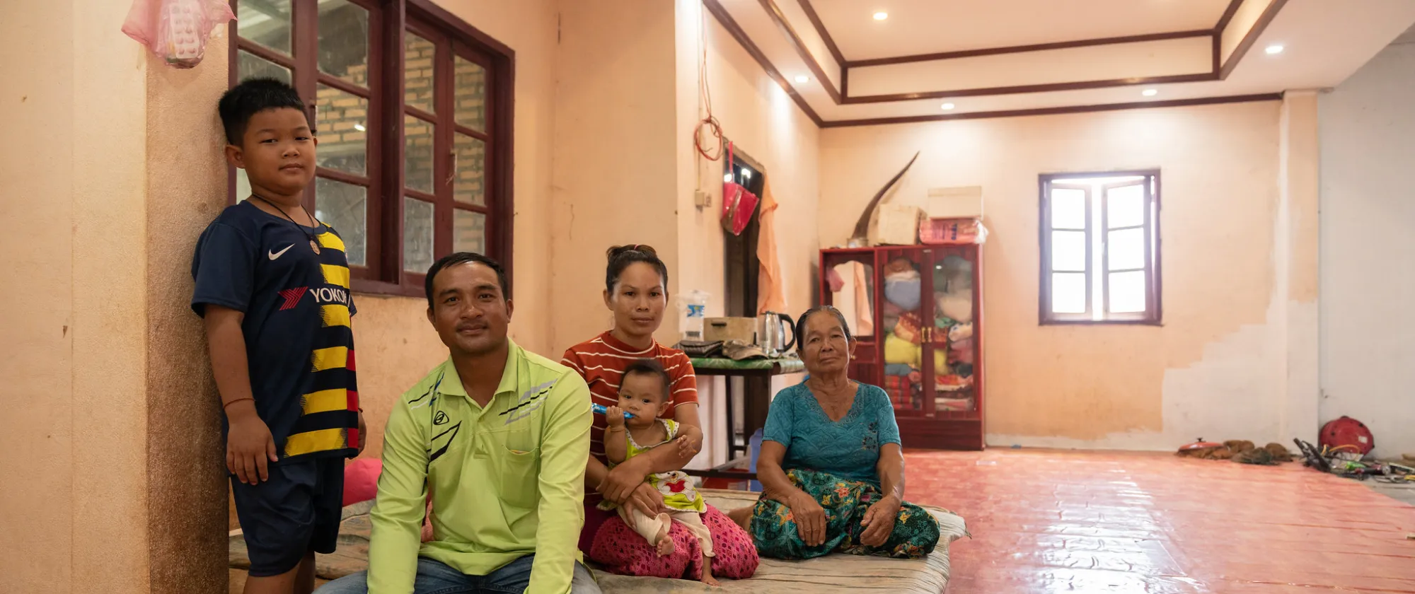 A family of five sit together in a house. 