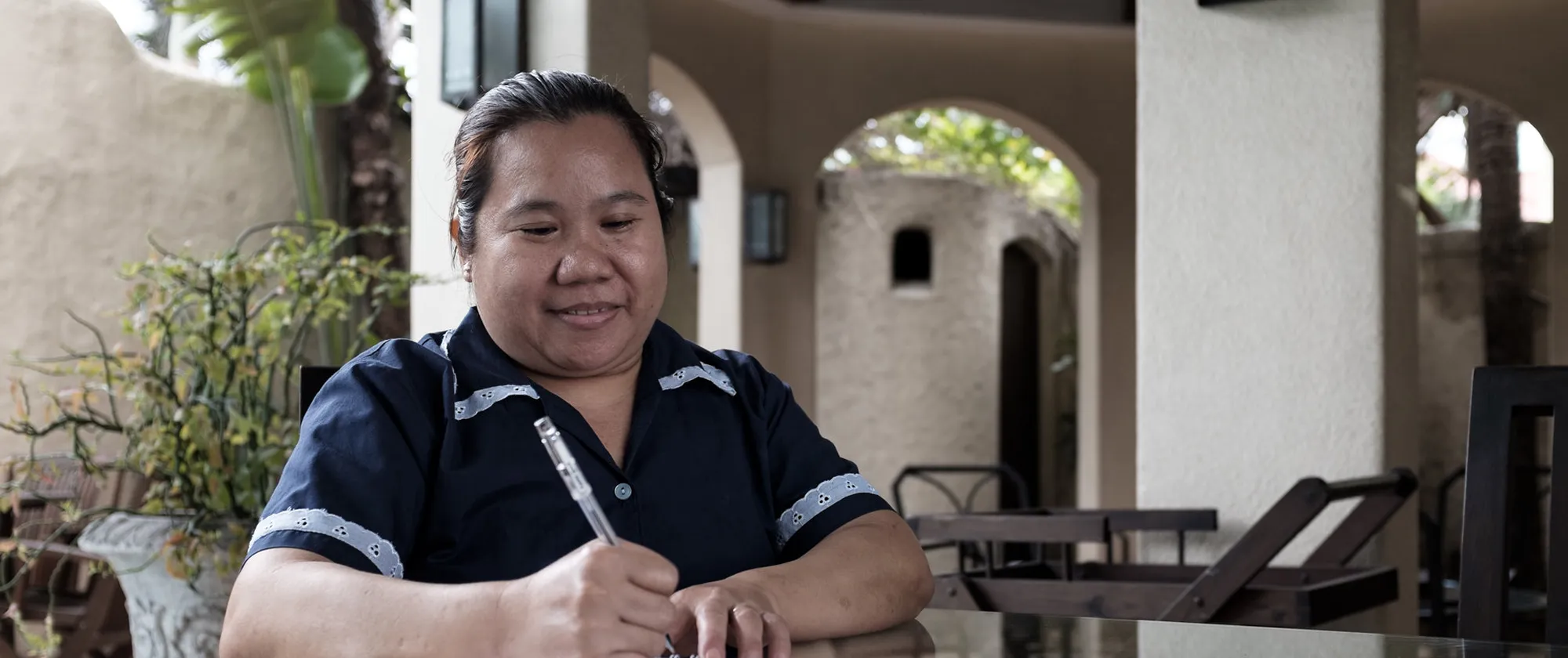 domestic worker writing on a notebook