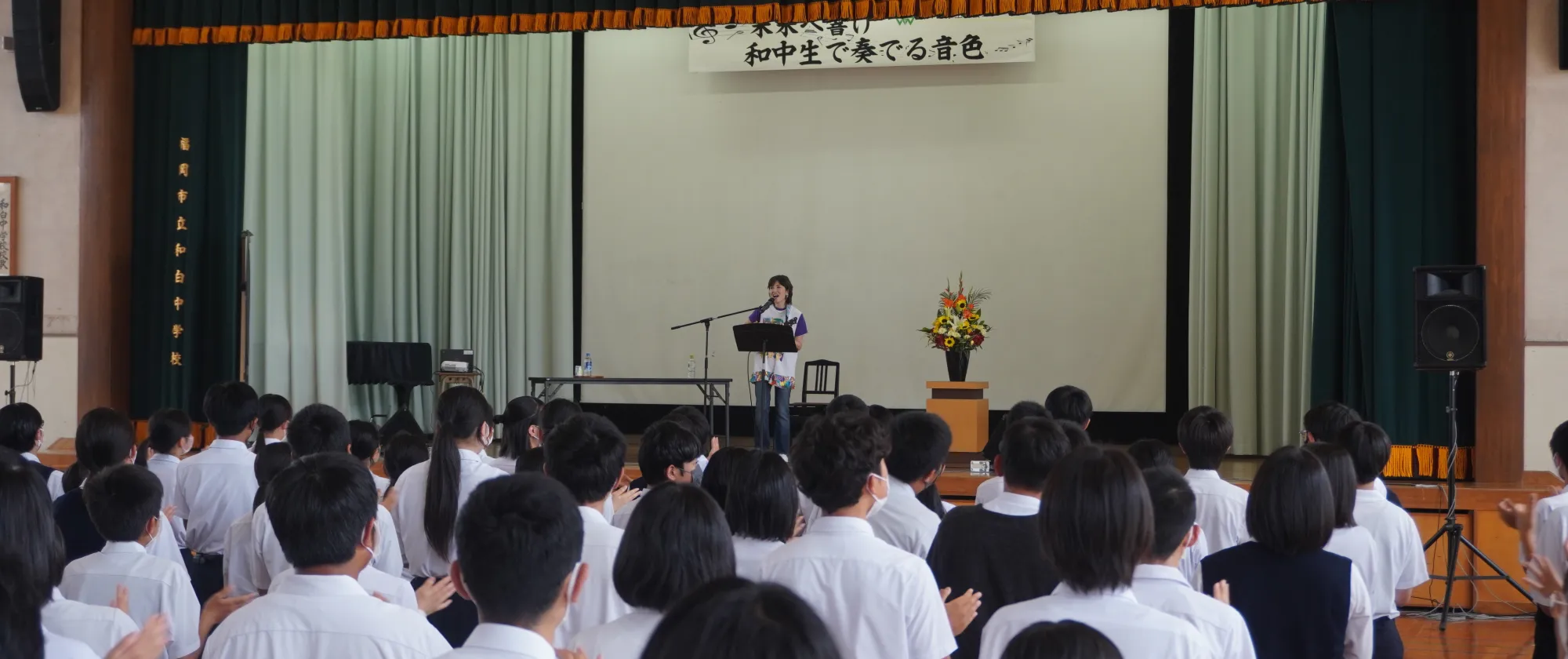 生徒や保護者ら約1200人を前に児童労働についての出張授業を行う歌手で「ILOサポーター」の荻野目洋子さん。「みんなの声を集めると大きな力になる」と語りかけた＝2022年6月10日、福岡市東区の市立和白中学校