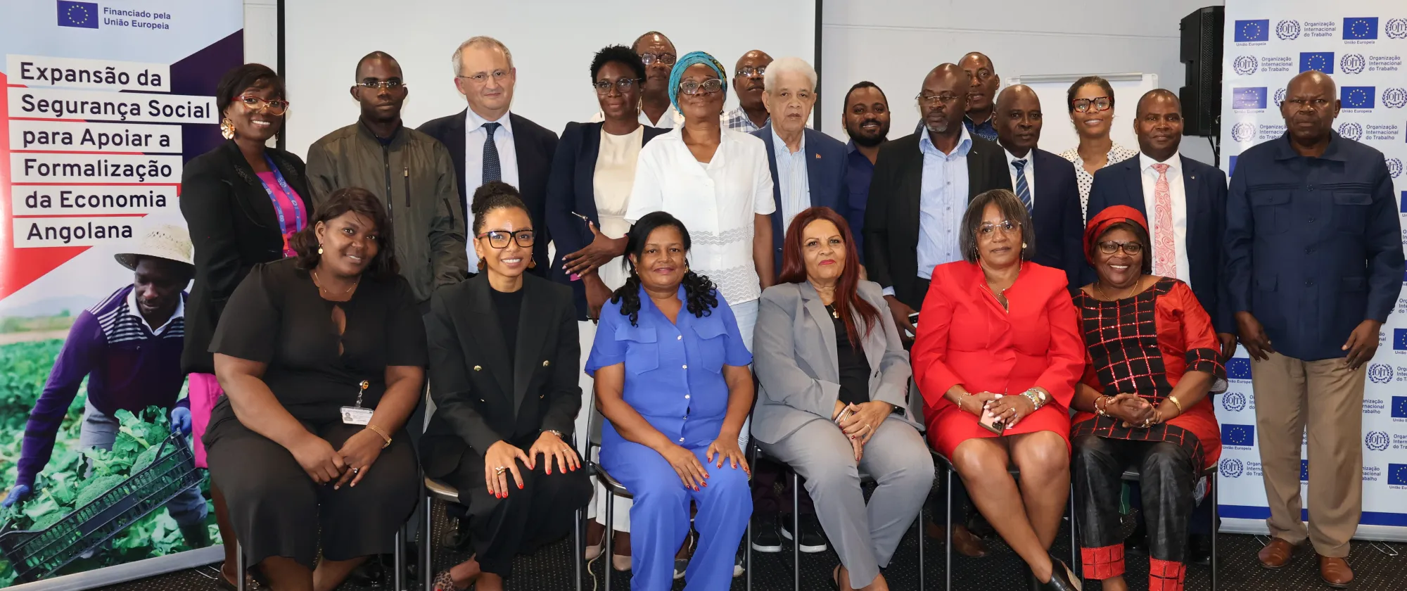 men and women of various ages and ethnic backgrounds, pose for a group photo at an event