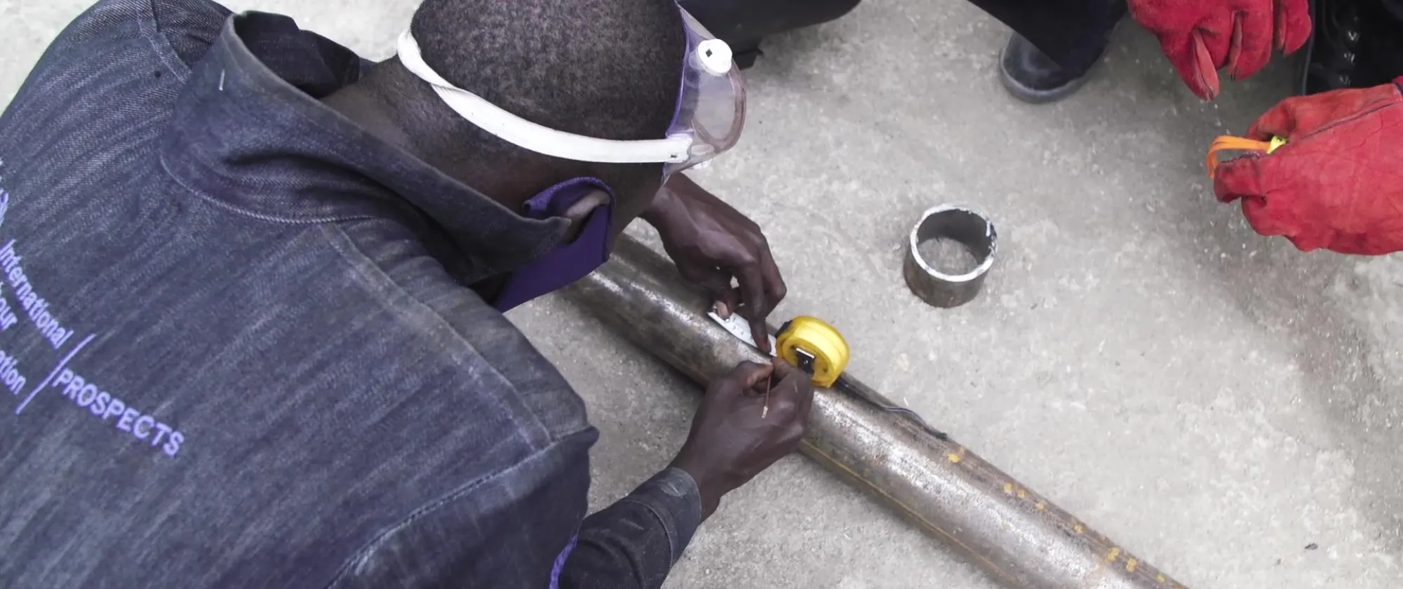 A welding student preparing metal before welding