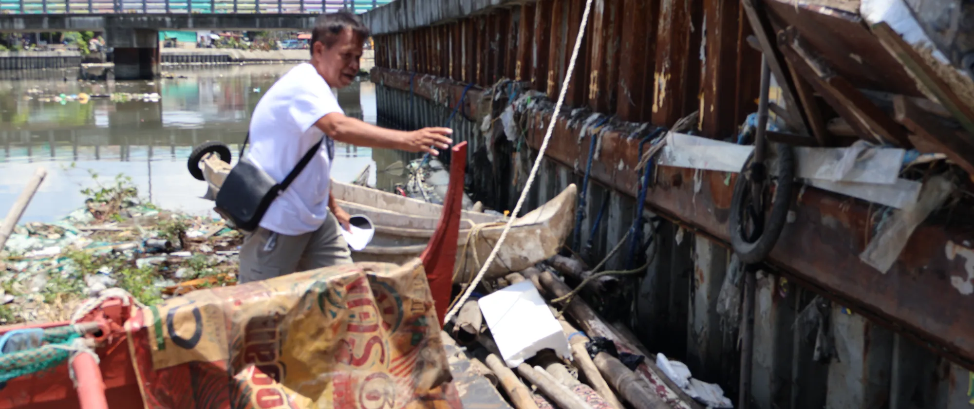 A fisher checks his boat along the river in Navotas.