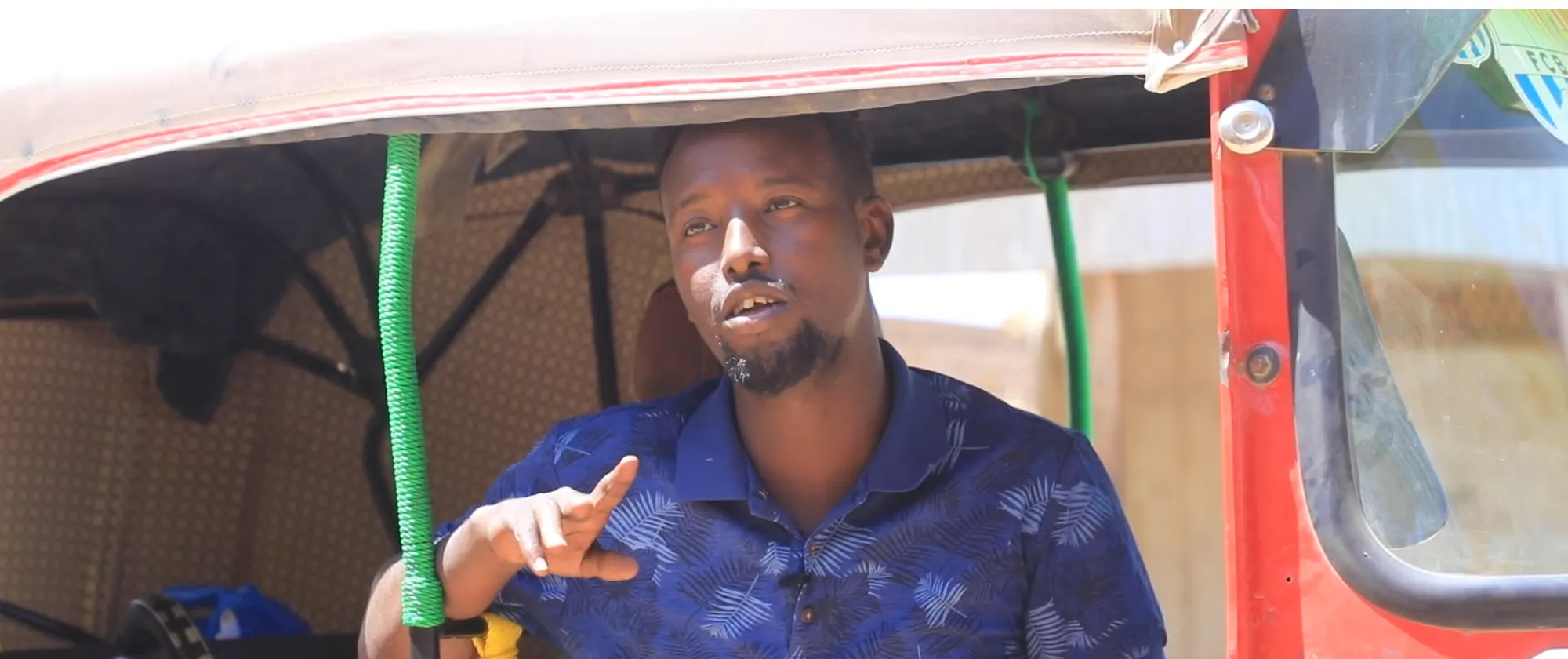 A three-wheeled taxi driver sitting in his vehicle.
