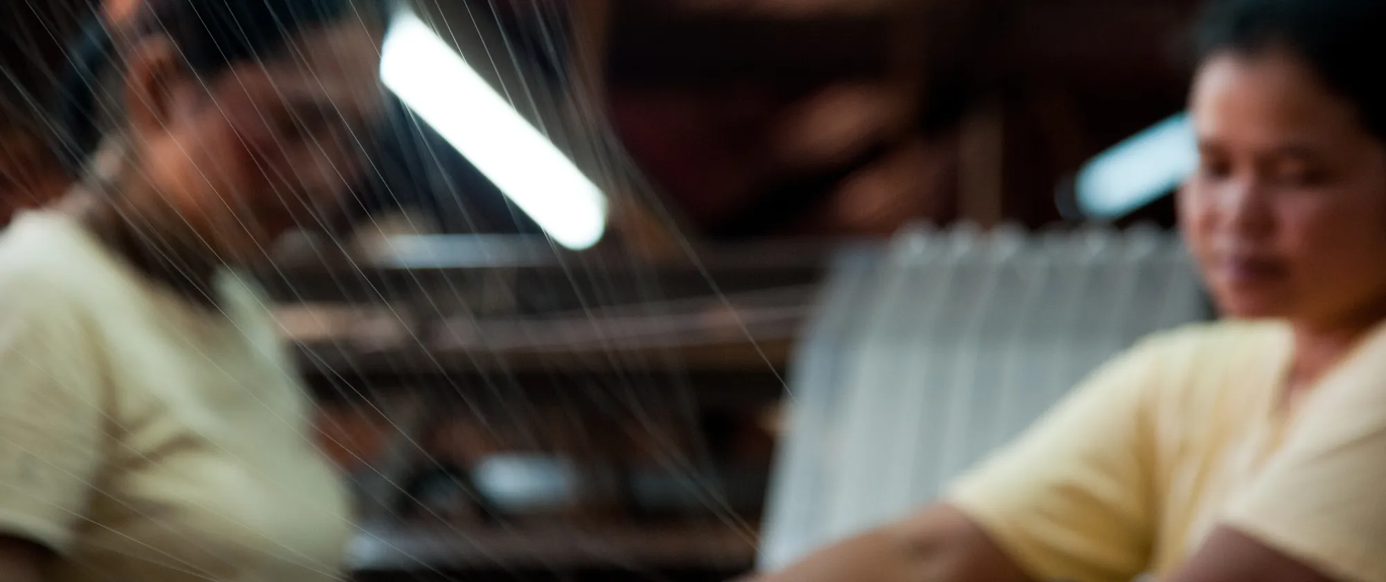 two women workers operating a weaving machine