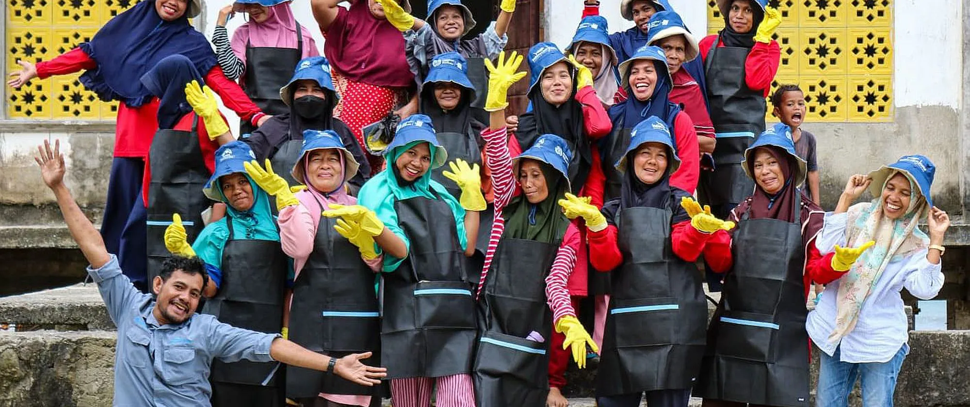 A group photo of women and men wearing colourful hats and outfits.
