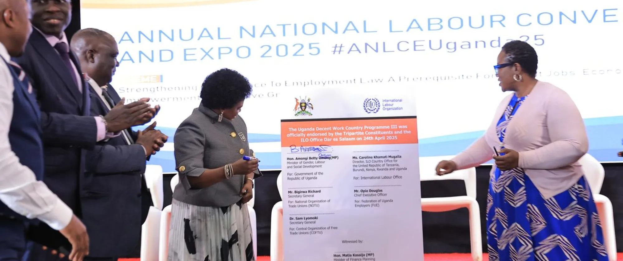 The ILO and the Government sign DWCP for Uganda, some people applaud next to the signatories 