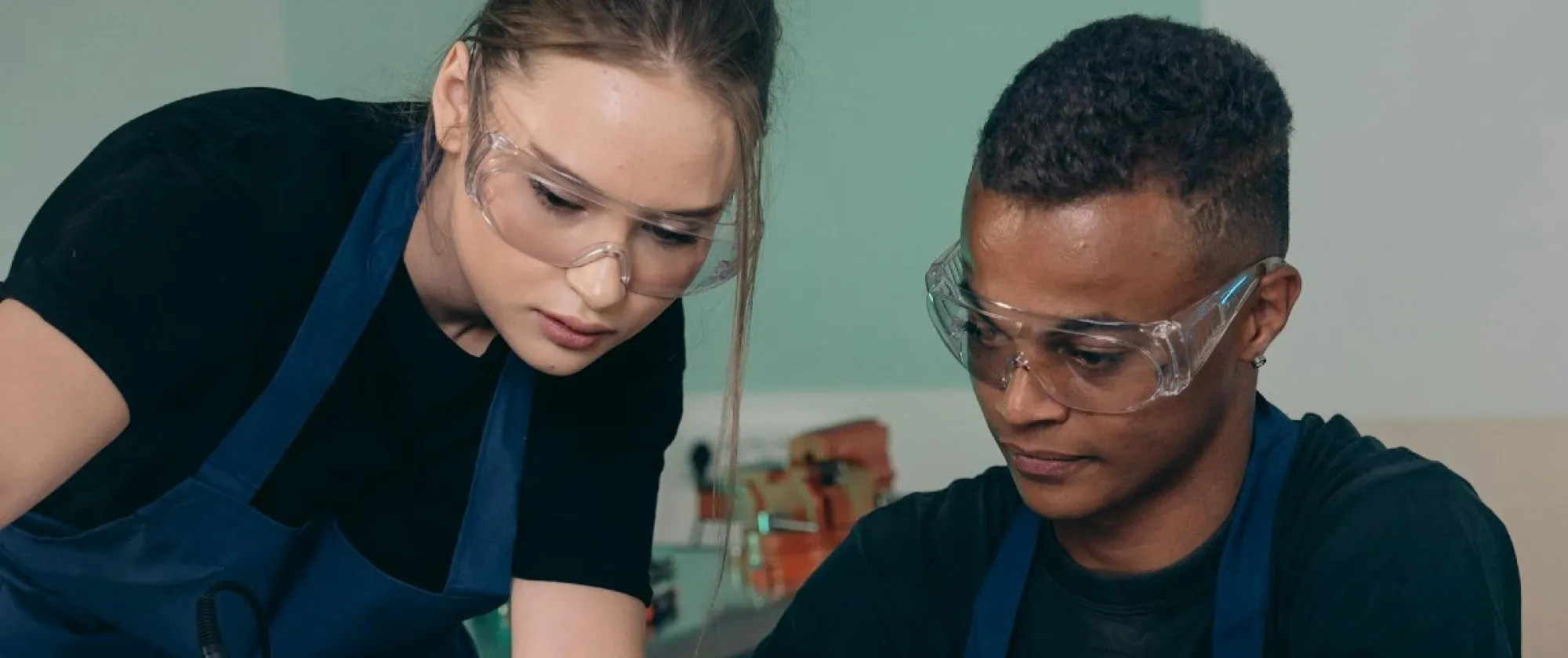 A woman and man fixing an electronic