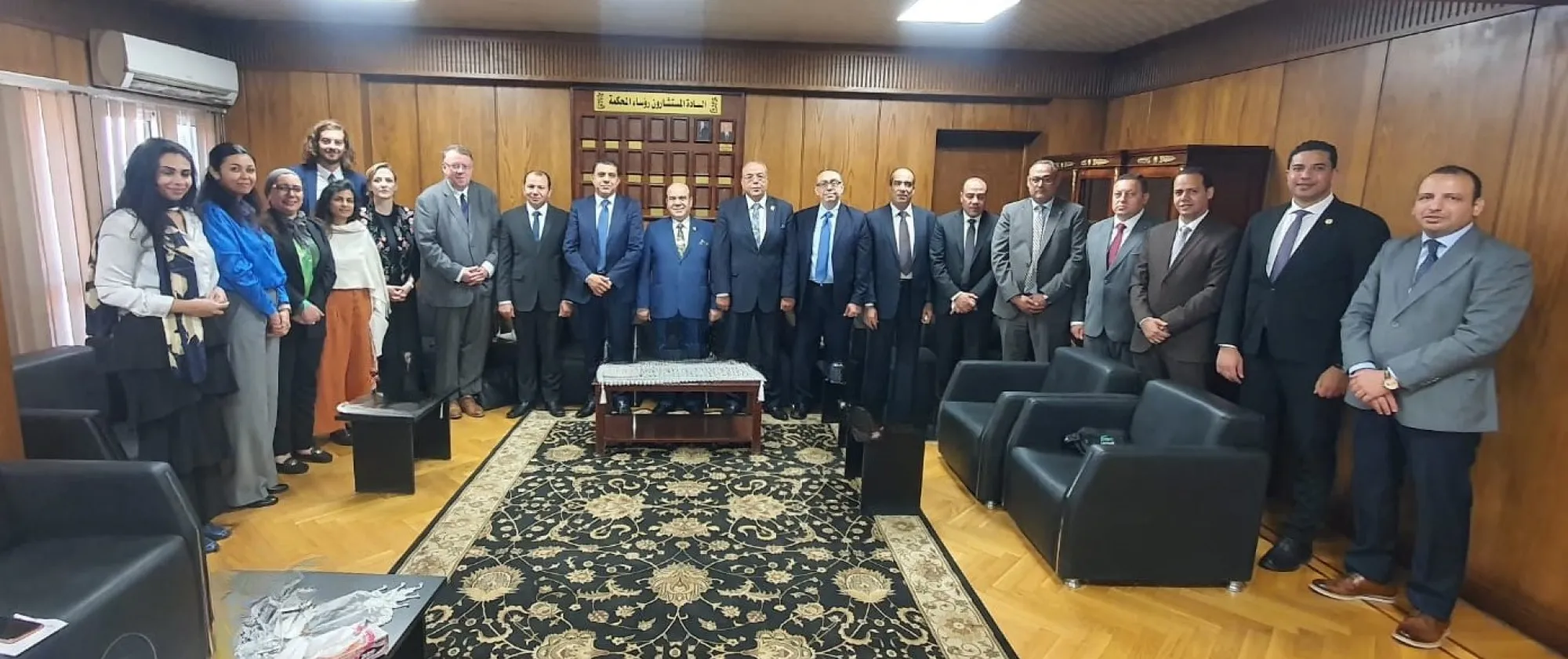 1. A group of professionals in suits and ties standing together in a well-lit conference room.