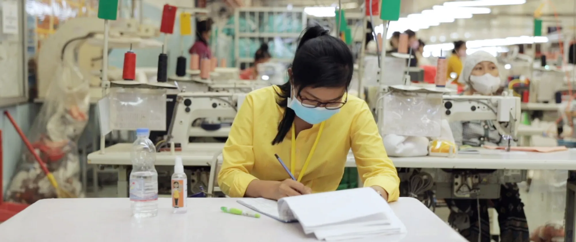 Woman worker taking notes on a logbook in a garment factory