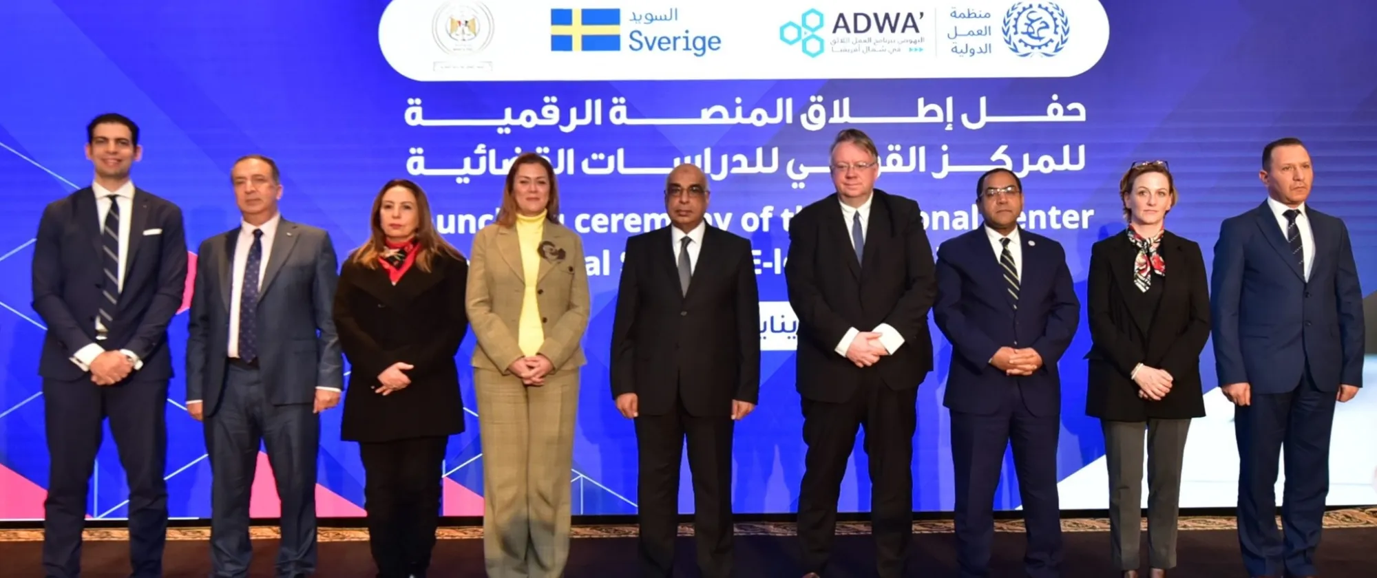 Group photo of officials from Egypt’s Ministry of Justice and the ILO standing in front of a digital backdrop during the launch of the NCJS e-learning platform.