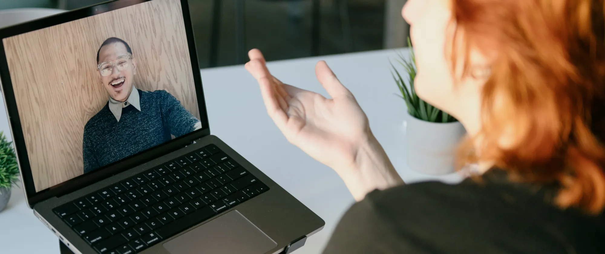 A woman talking to a man via a laptop