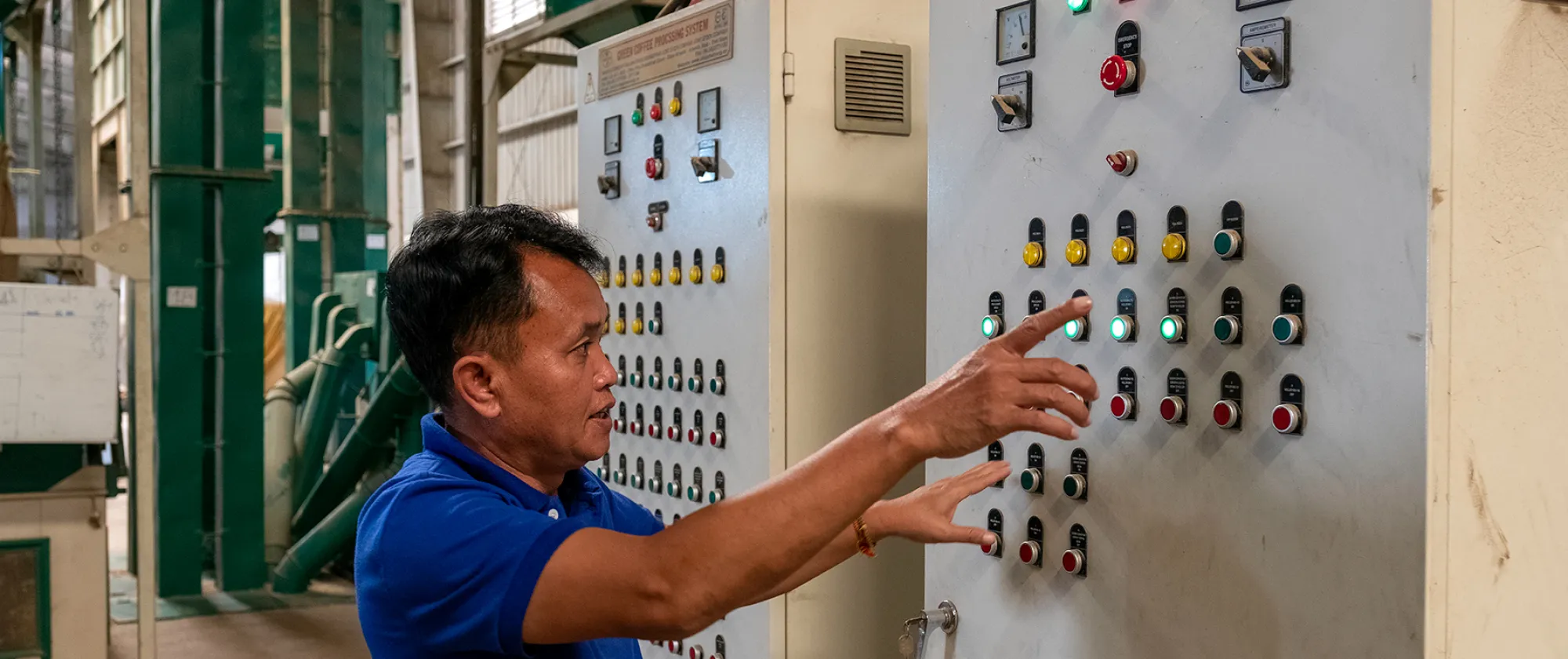 Man operating an electric panel in a factory