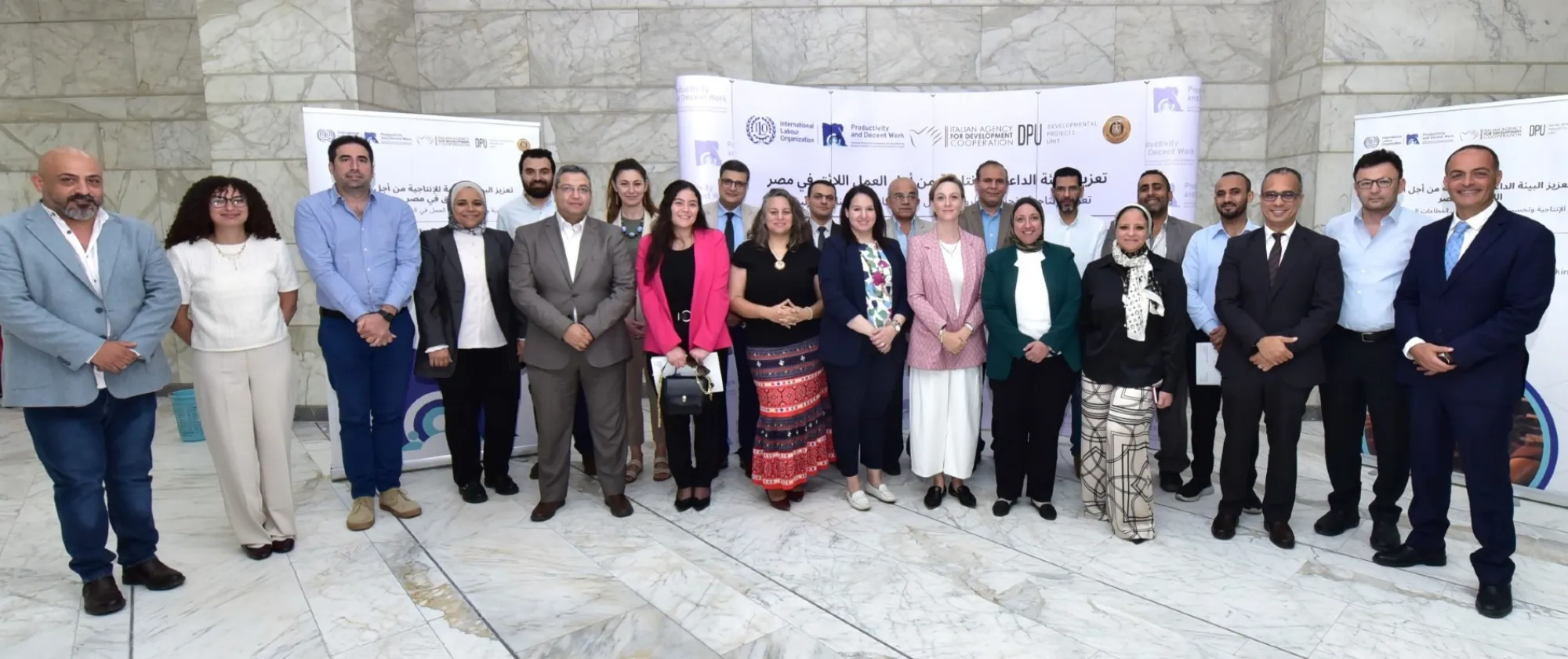 Participants gather in front of a banner during the first day of a workshop on Egypt's leather and marble industries in Cairo.