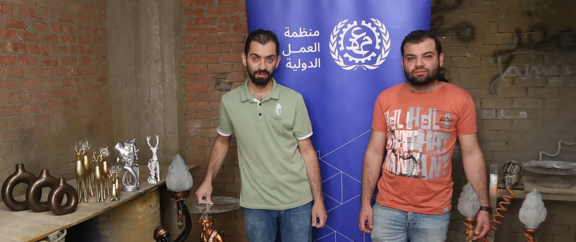 two men posing with with their products at their workshop