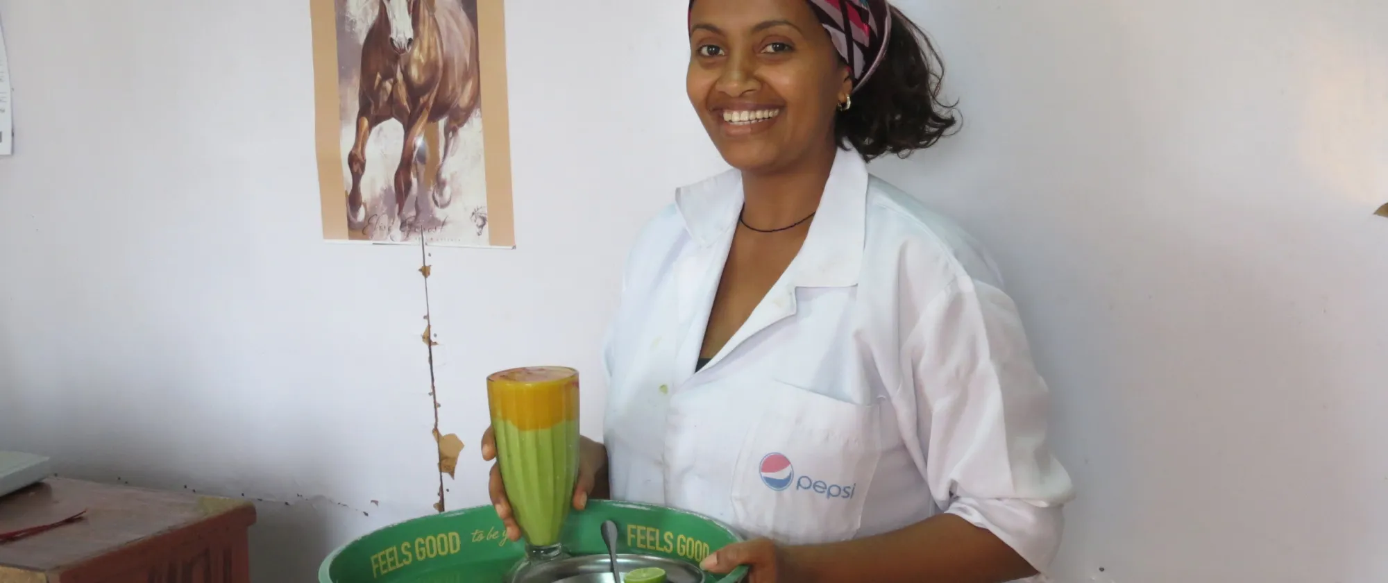 BRMM beneficiary holding juice and smiling at the camera