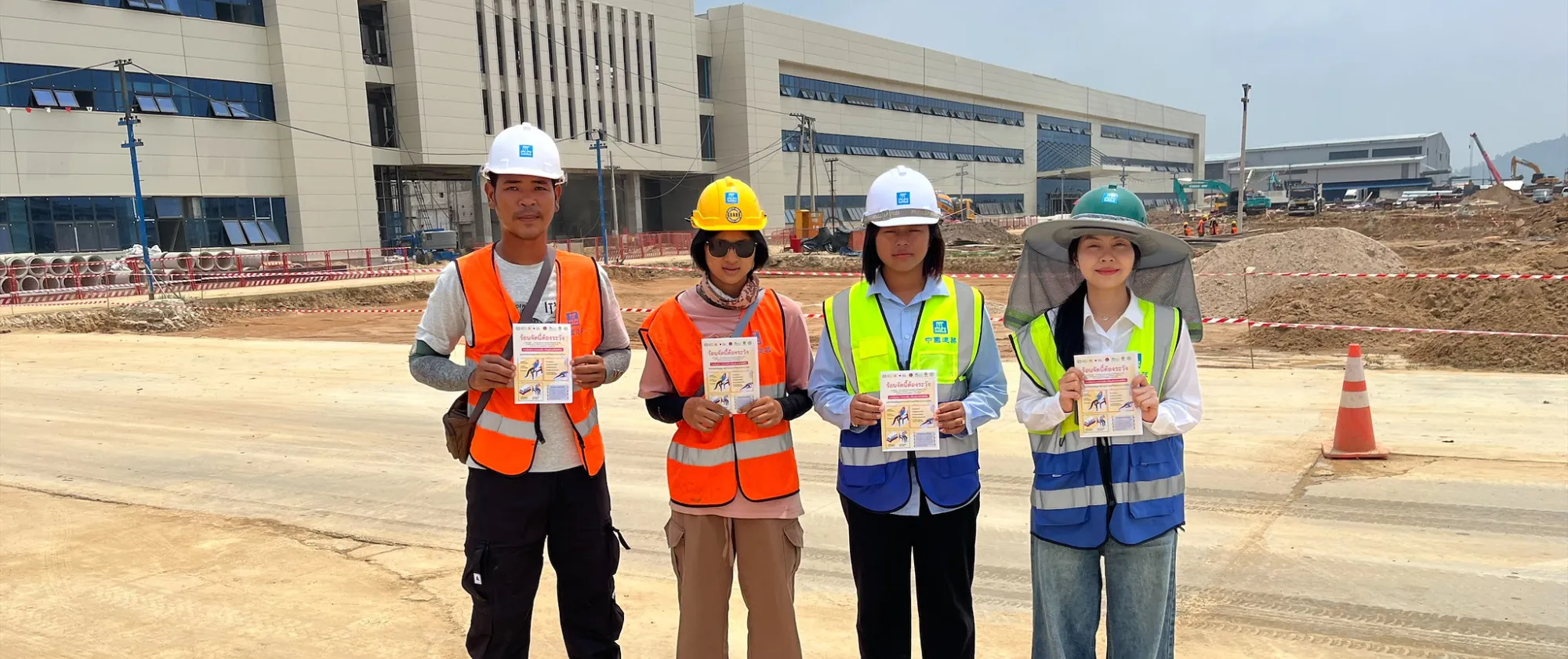A ground of female and male workers holding brochures.