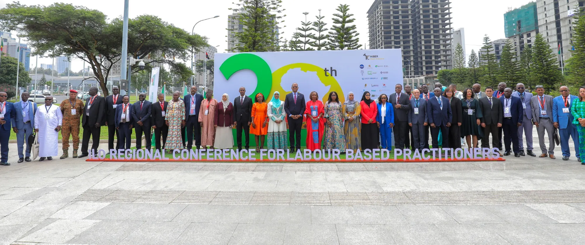 Group photo of participants in front of the conference sign