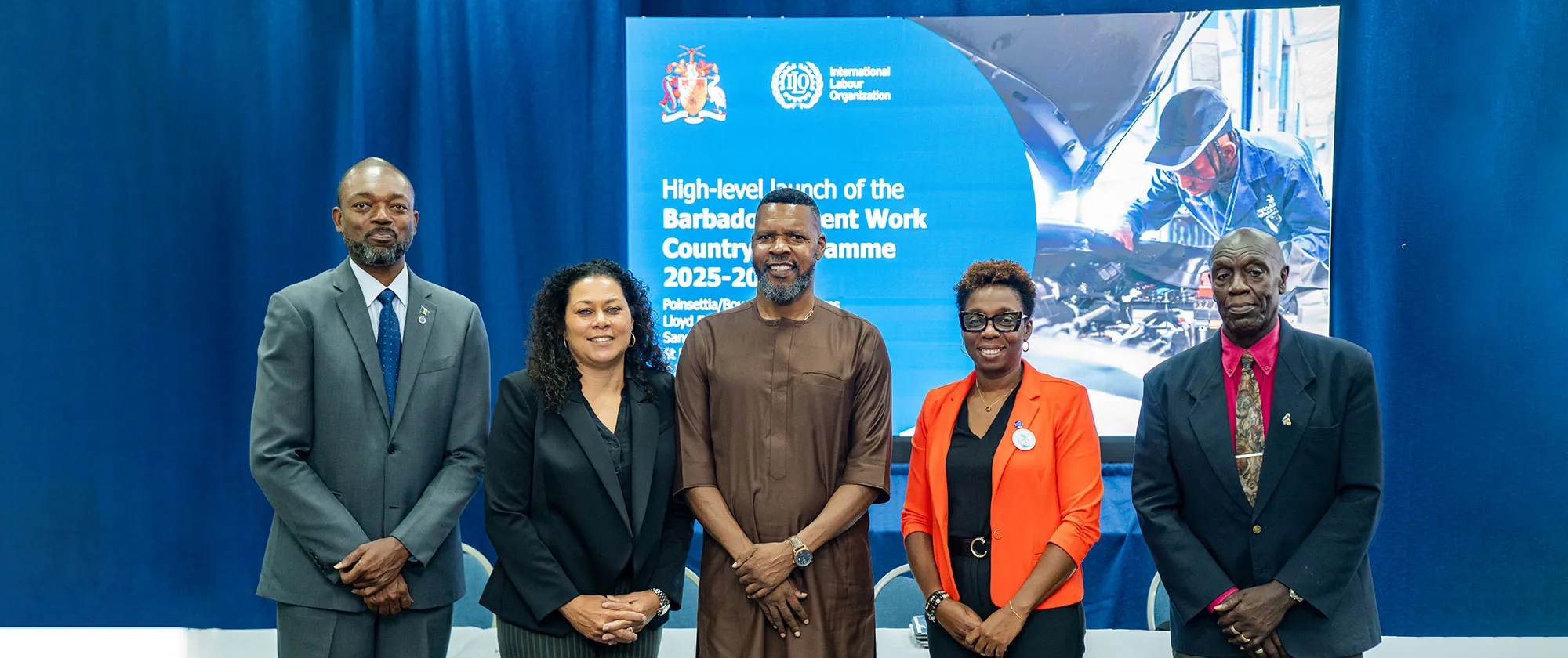 Five individuals stand together in front of a backdrop during the high-level launch of the Barbados Decent Work Country Programme 2025–2030 on 02 July 2025. 