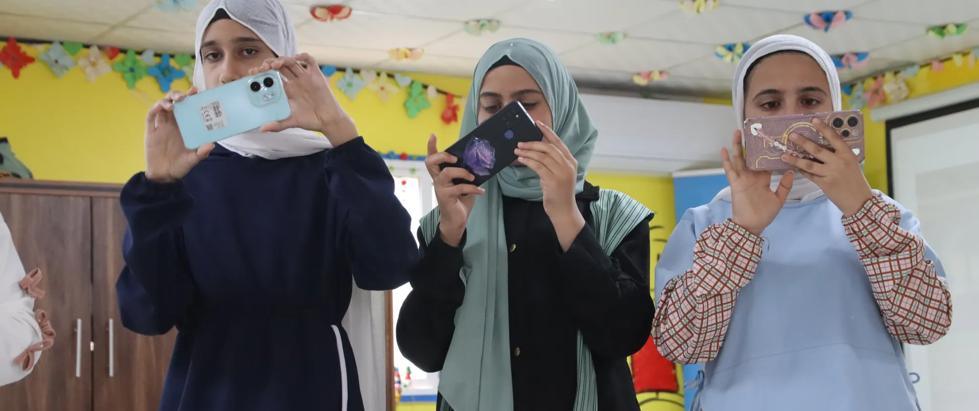 THREE trainees practicing photography techniques during a training session in Amman, Jordan.   15 May 2025