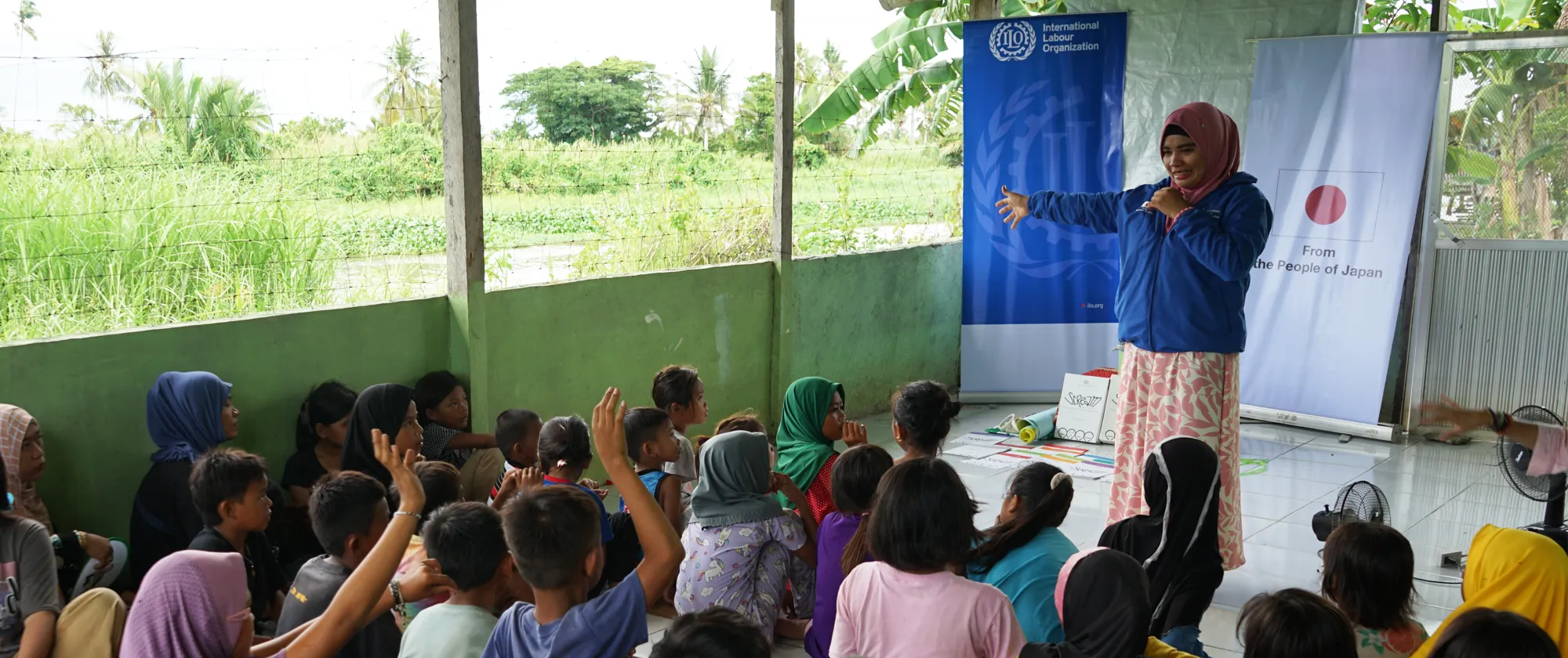 teacher standing with child labourers learning