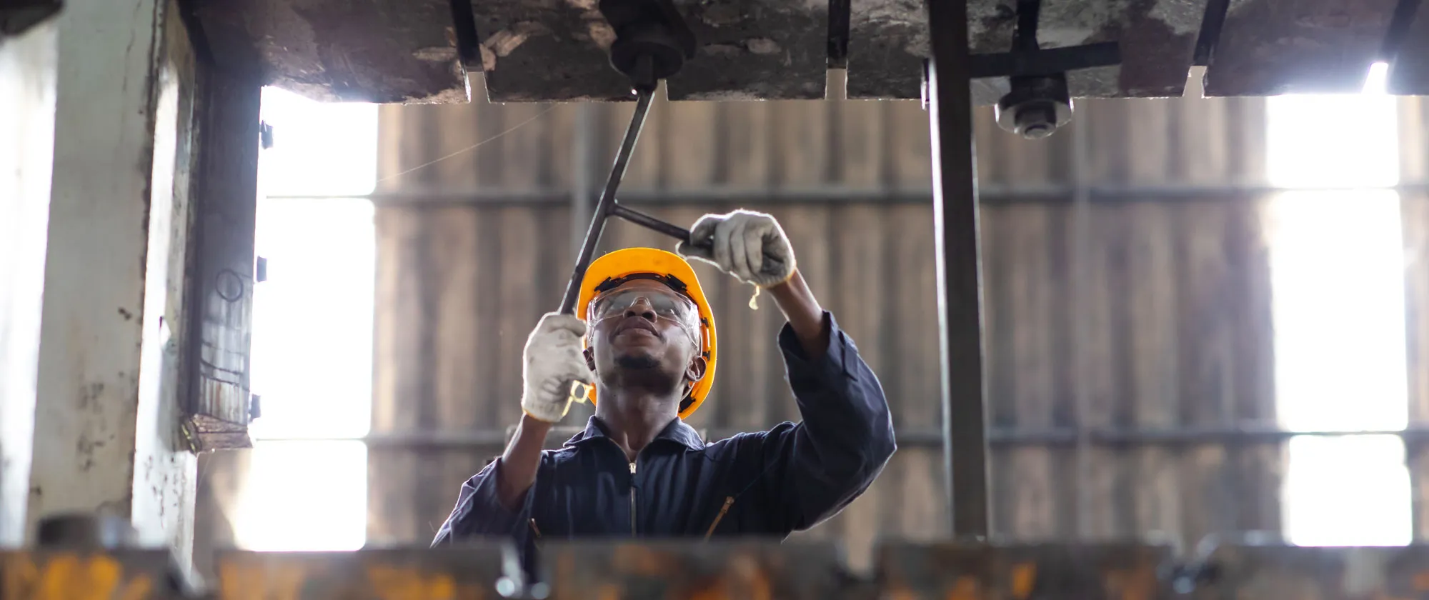 Young black male engineer checking and repairing the machine in Heavy Industry Manufacturing Facility