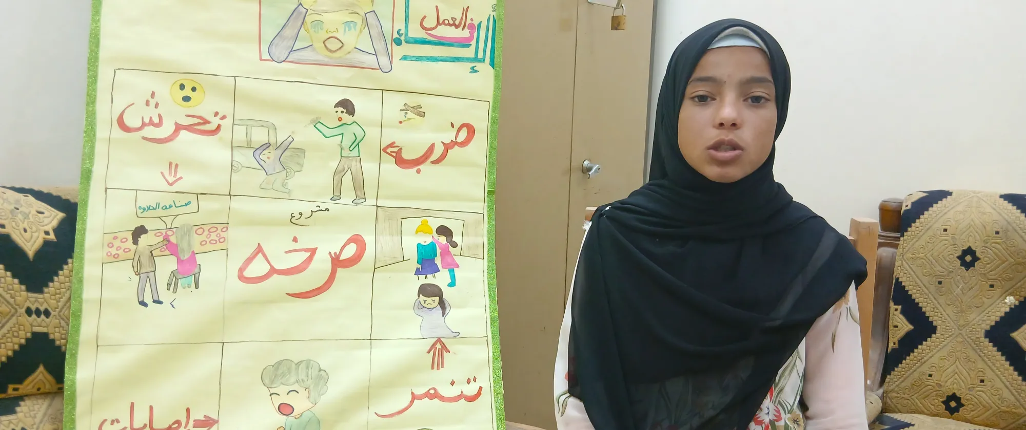 Mahasen, a 15-year-old girl from Egypt stands next to a poster of her making.
