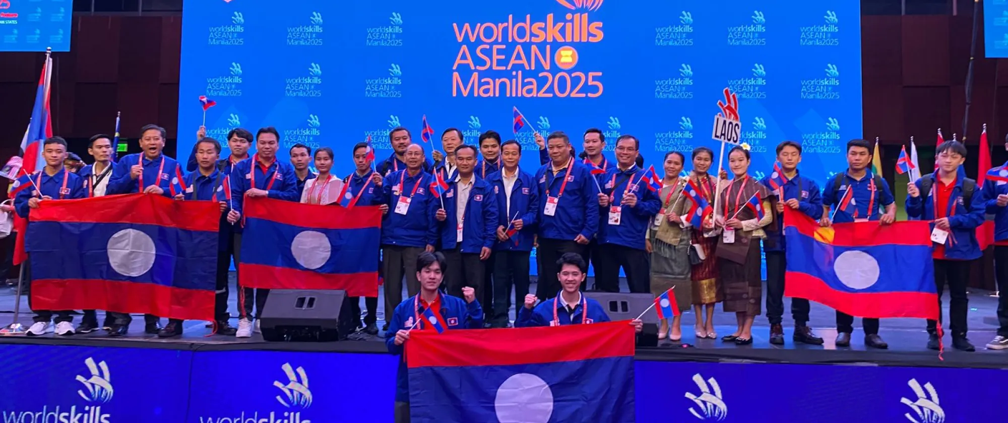 People carrying flags on a stage.  
