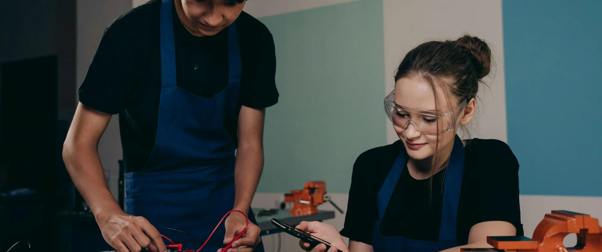 Woman and Man by Table with Electronics