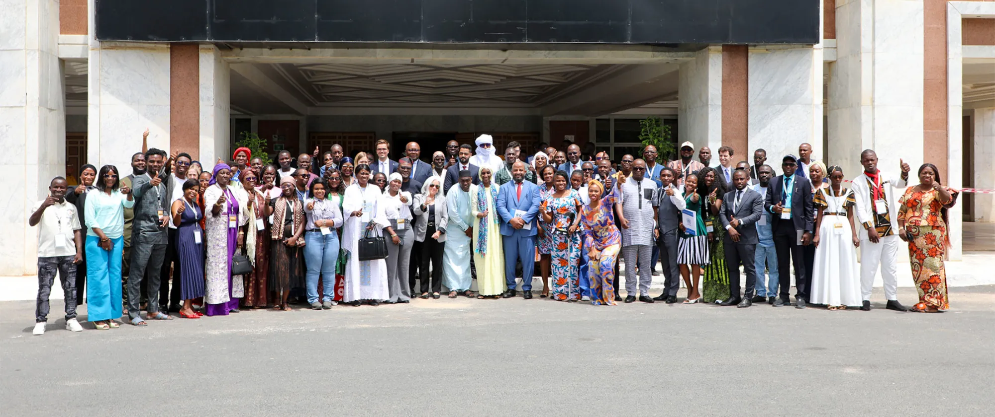 Participants gathered outside the venue at the opening of the 4th Annual West Africa and Sahel Youth Forum in Dakar, featuring young women and men, government officials, and partners.