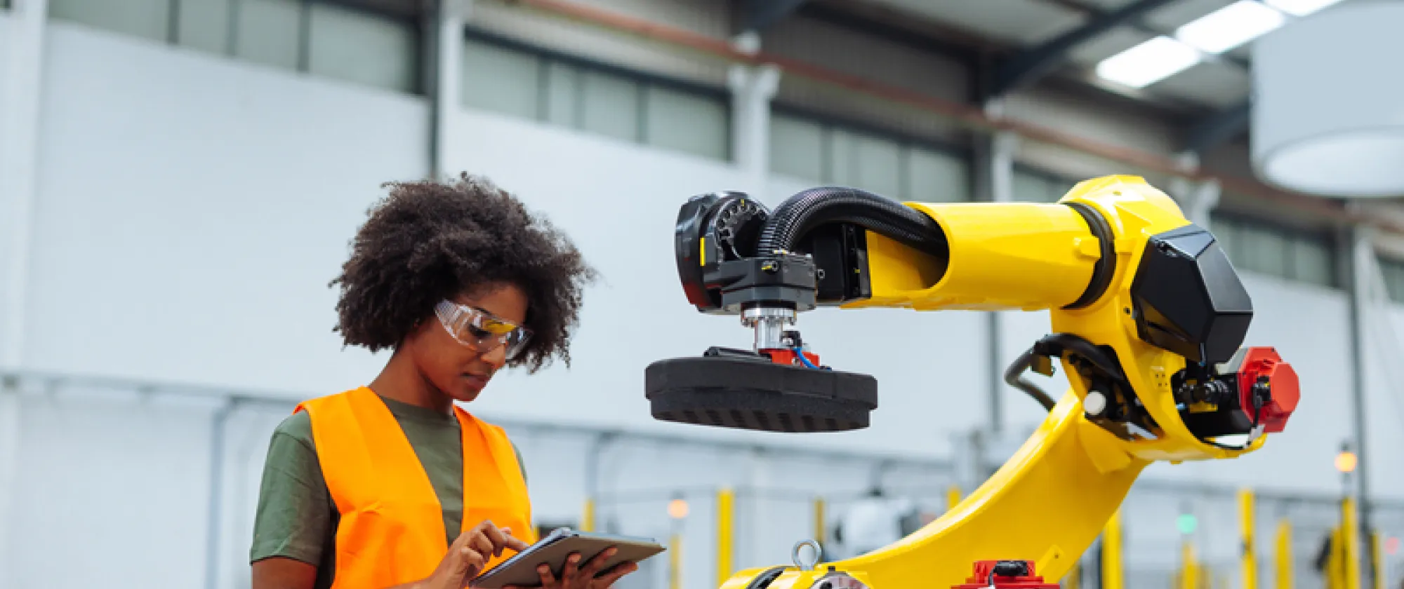 Young african woman controlling industrial machine with digital tablet 
