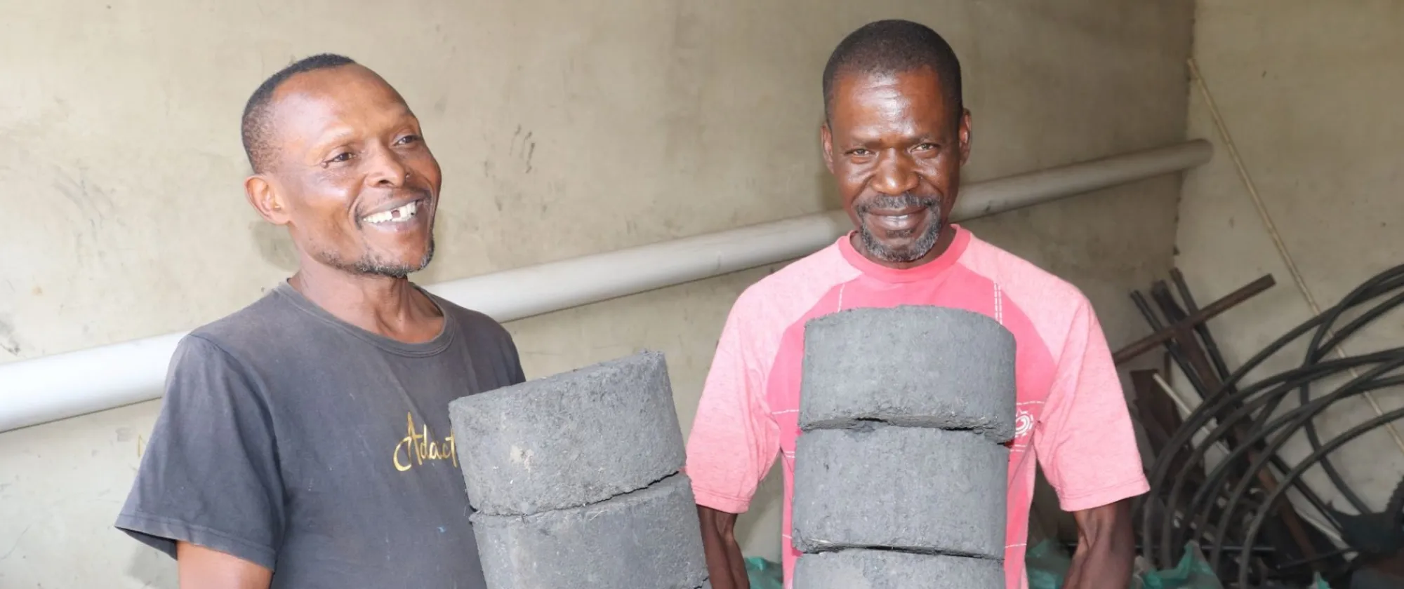 2 men holding charcoal briquettes