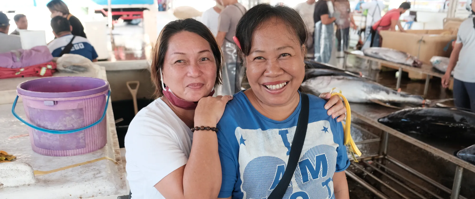 two women smiling at the camera in the fishing port of General Santos in the Philippines