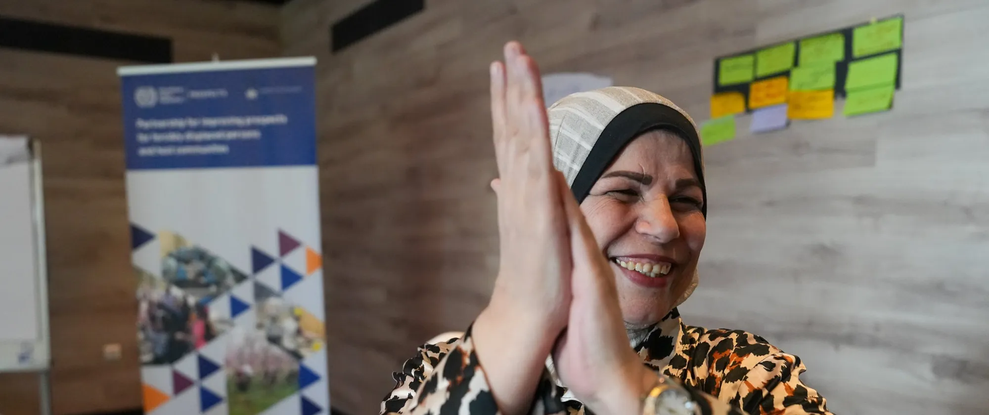 refugee woman attending an ILO training cheering 