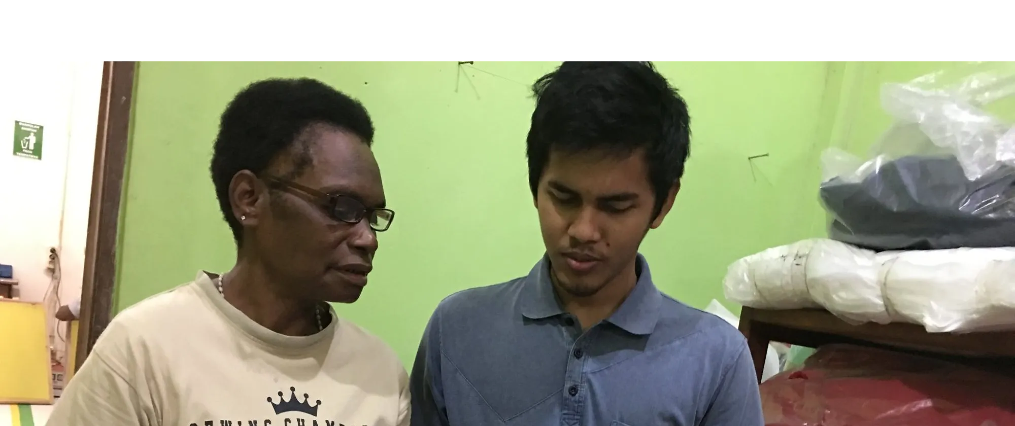 a male university student assists a female entrepreneur in Papua, Indonesia 