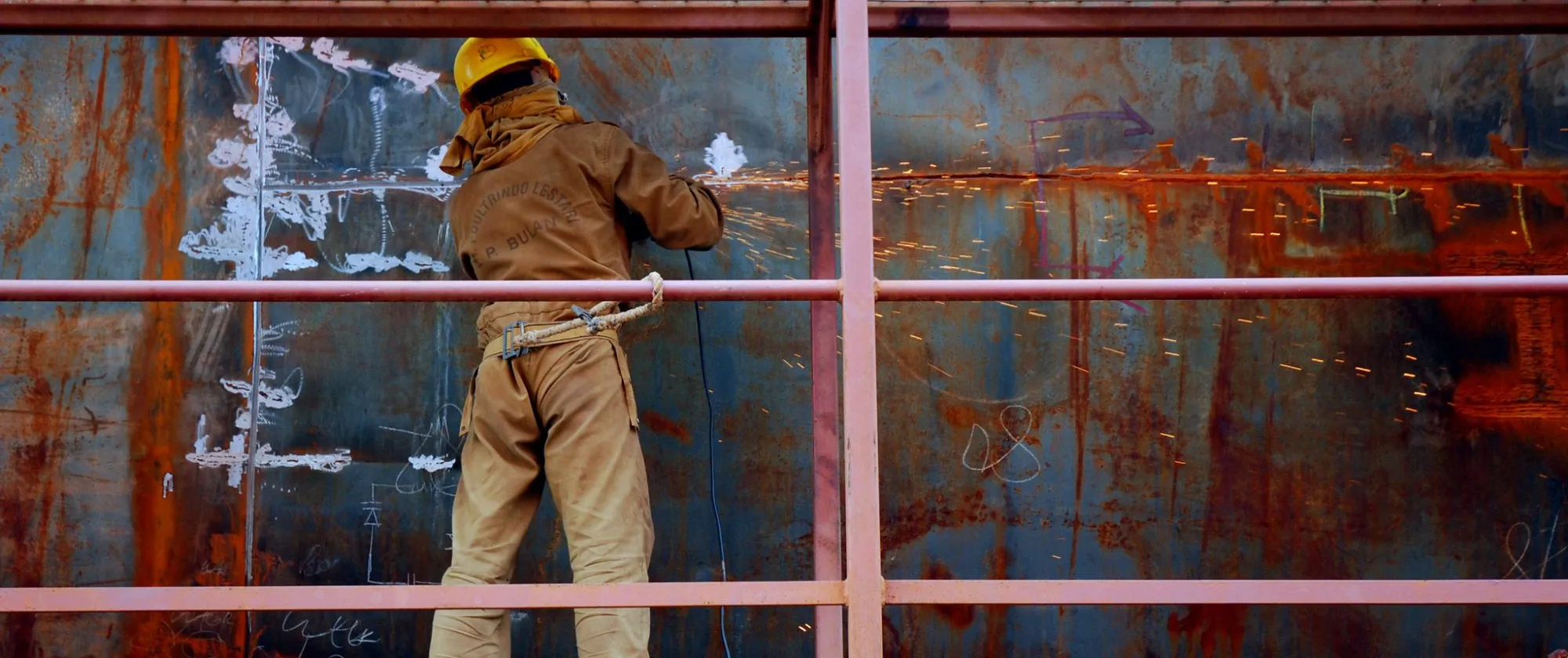 a male worker repairing a ship in a shipyard 