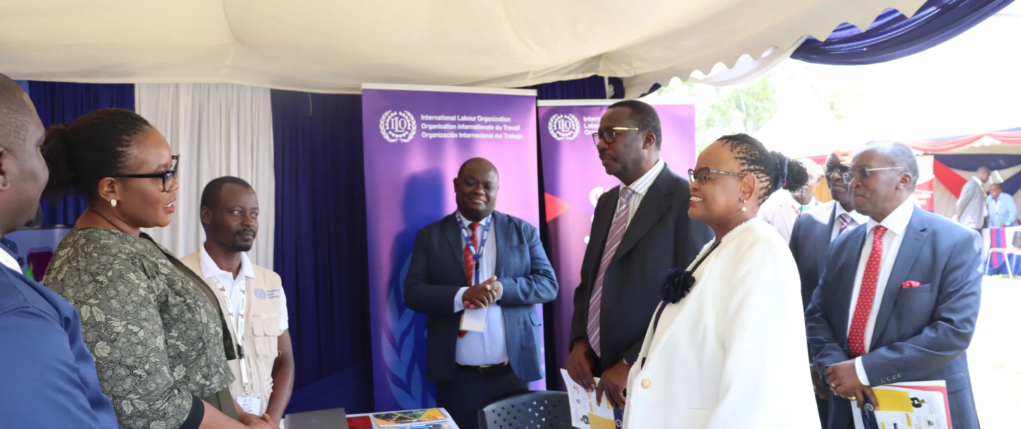 Photo of ILO Director Country Office Dar Es Salaam Caroline Khamati Mugalla welcoming the Chief Justice & President of the Supreme Court of Kenya, leadership from the Judiciary, and other partners to the ILO booth during ELRASE III.