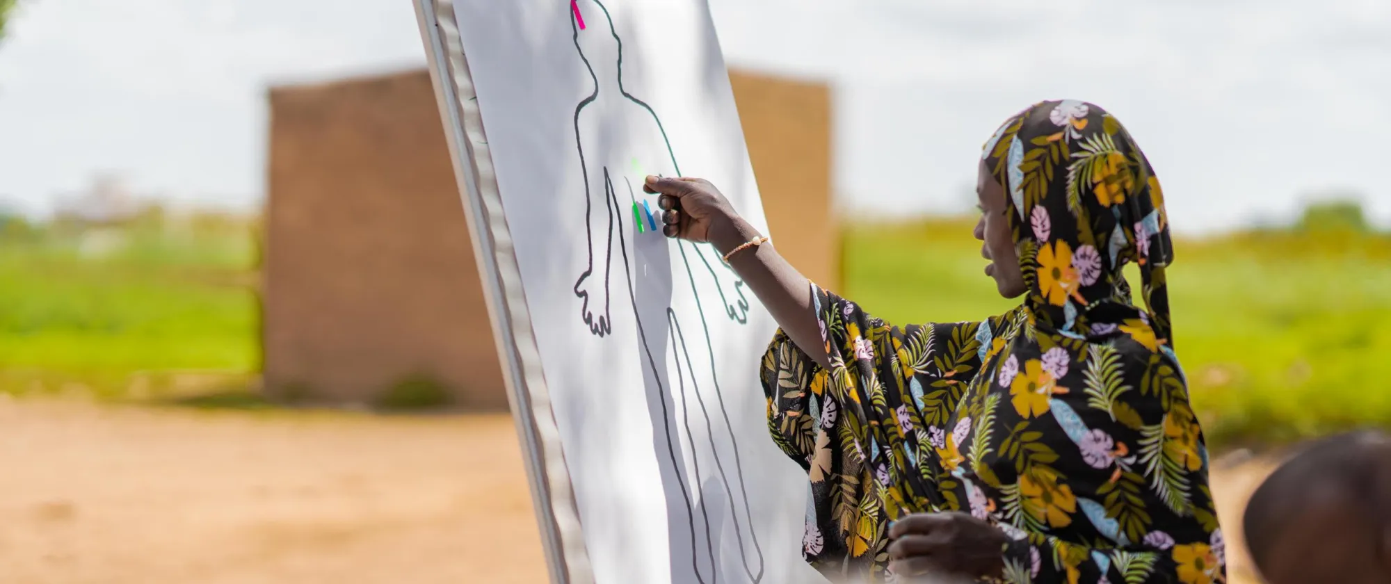 Participant to a training points out to parts of the body in a diagram 