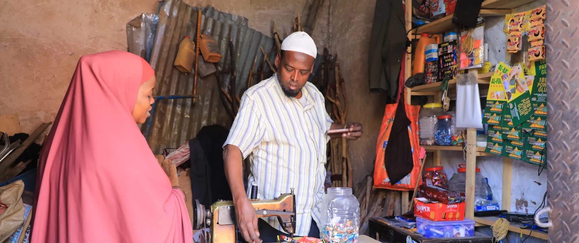 Mohamed Sheikh Gudoow, a trader and a father of five, serving a customer at his shop in Sigaale Market 
