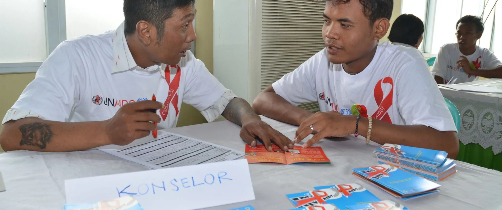 several participants in a room with HIV and AIDs brochures on the desks