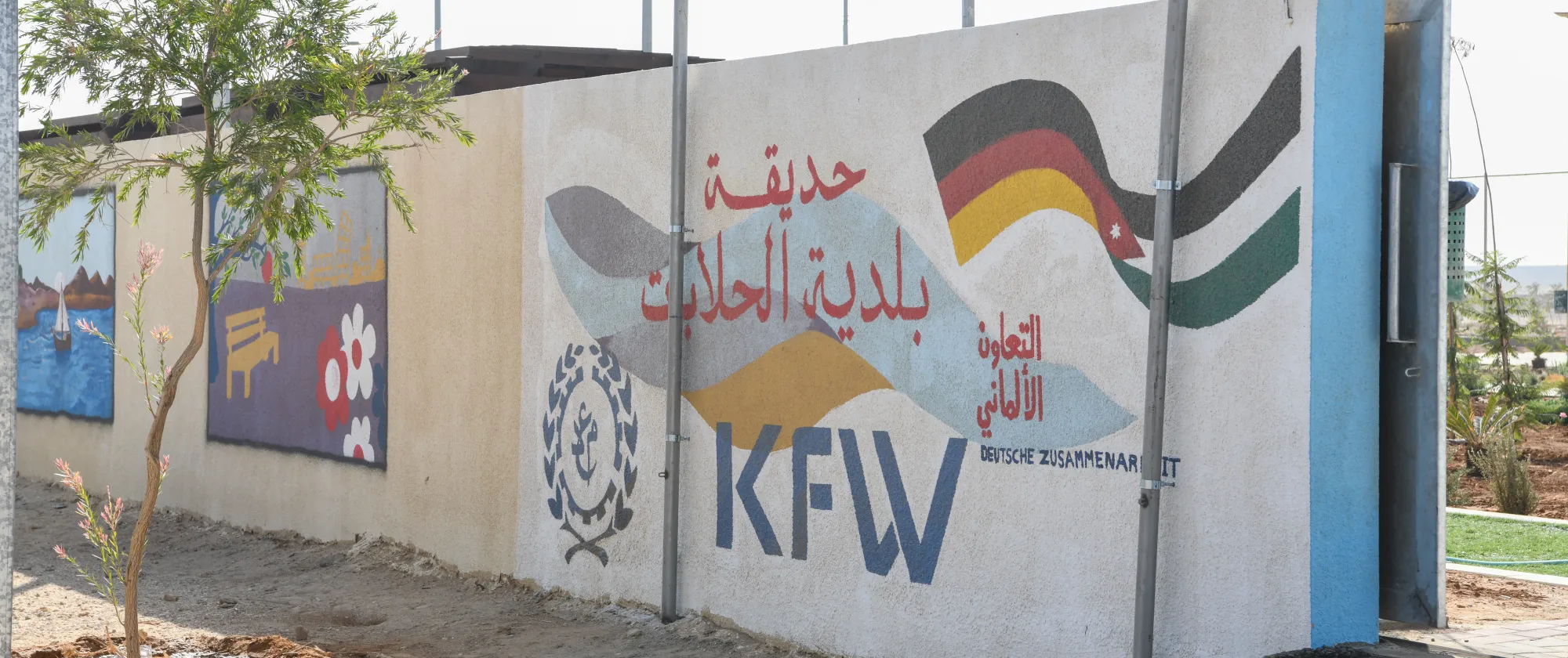 Mural at the entrance of the Hallabat Municipality Park and Playground highlighting the partnership between the Government of Germany through KfW and the International Labour Organization under the Employment-Intensive Investment Programme. Hallabat, Jordan, 10/2025.